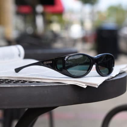 polarized fitover sunglasses sitting on a newspaper